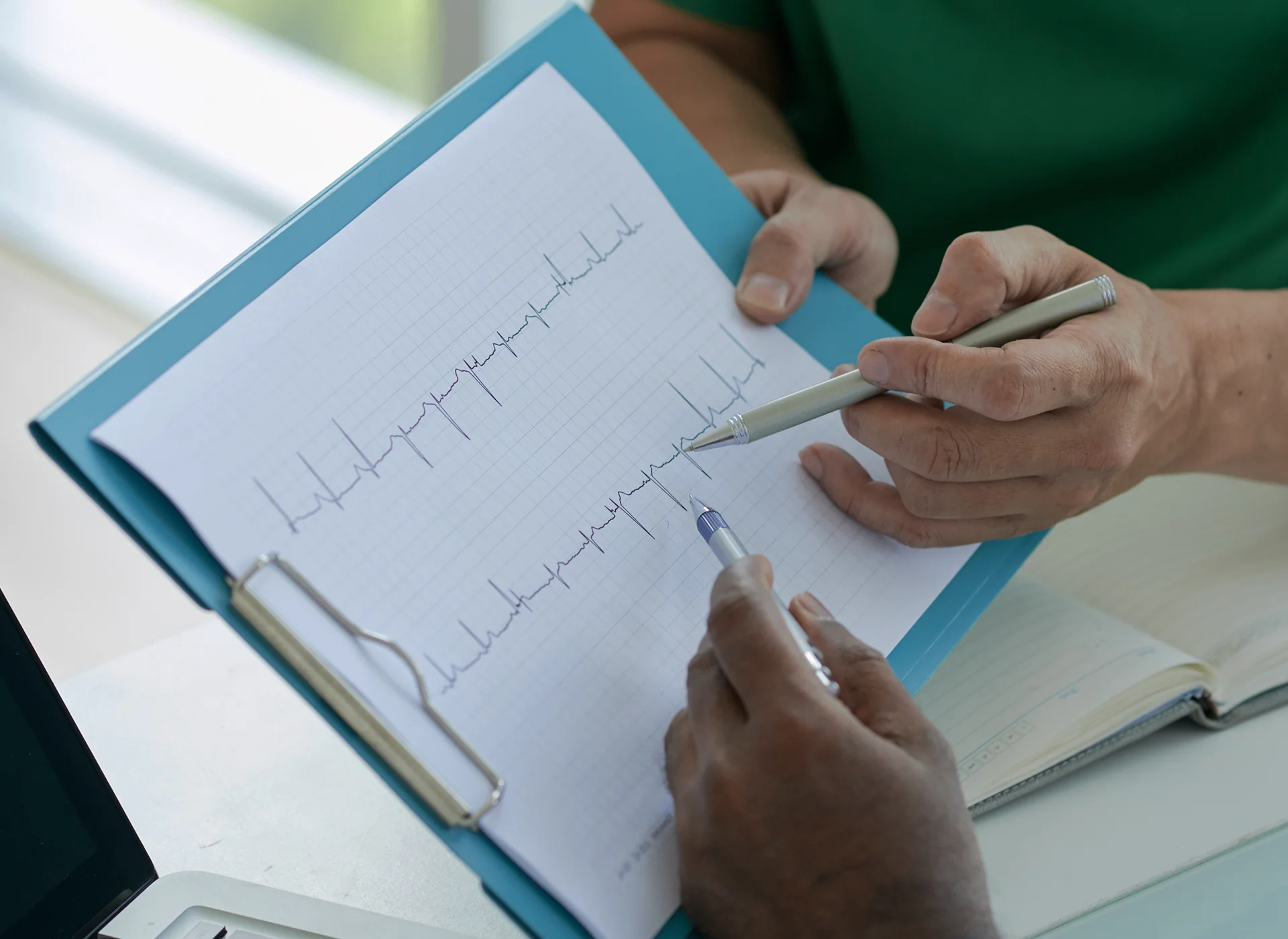 Primer plà del resultat imprès d'un electrocardiograma que s'està revisant.